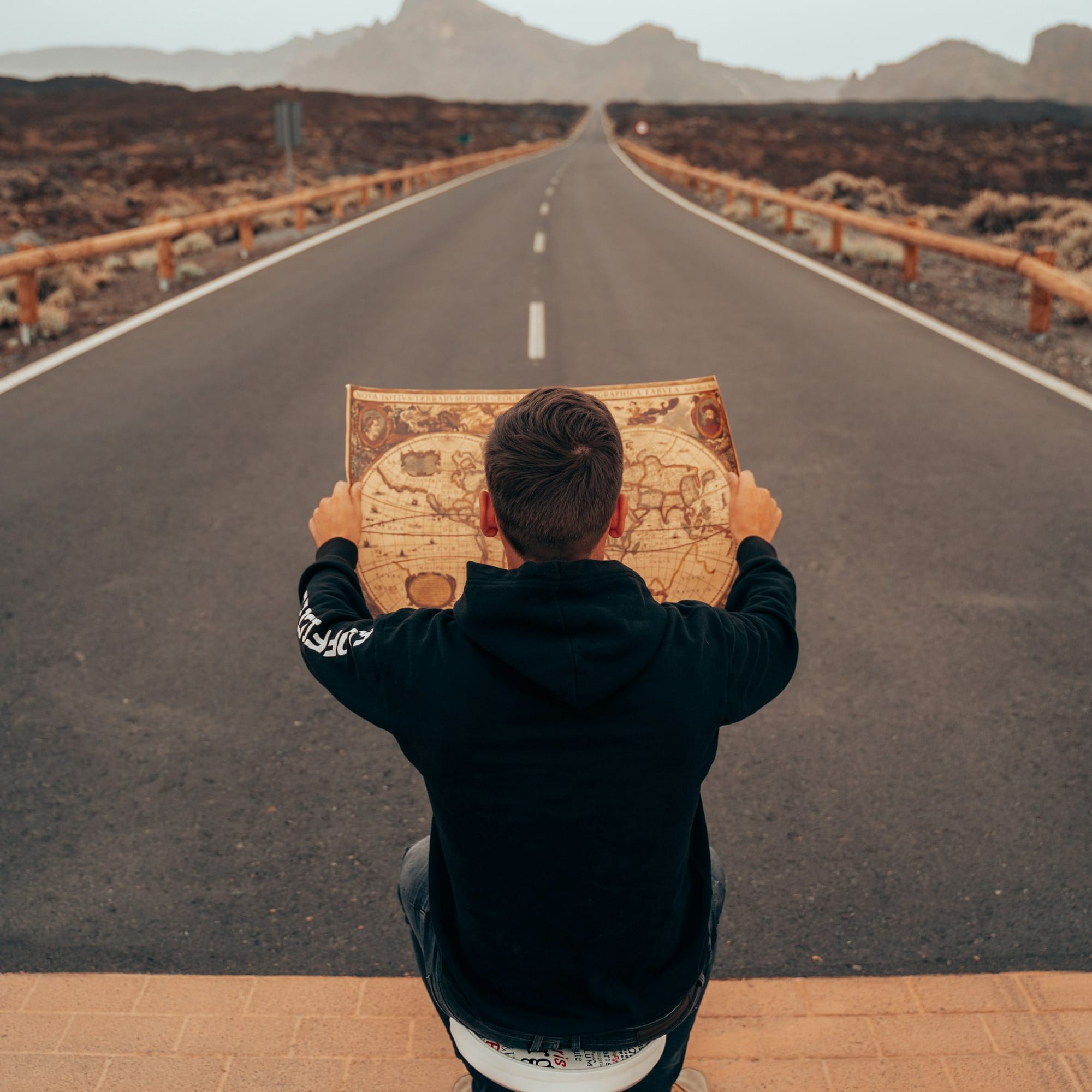 man in black jacket holding brown box